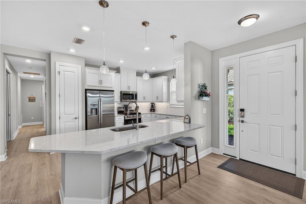 15641 Gavello Street Naples, FL 34114 - Photo 5 of 37 a kitchen with stainless steel appliances kitchen island granite countertop a refrigerator and a stove top oven