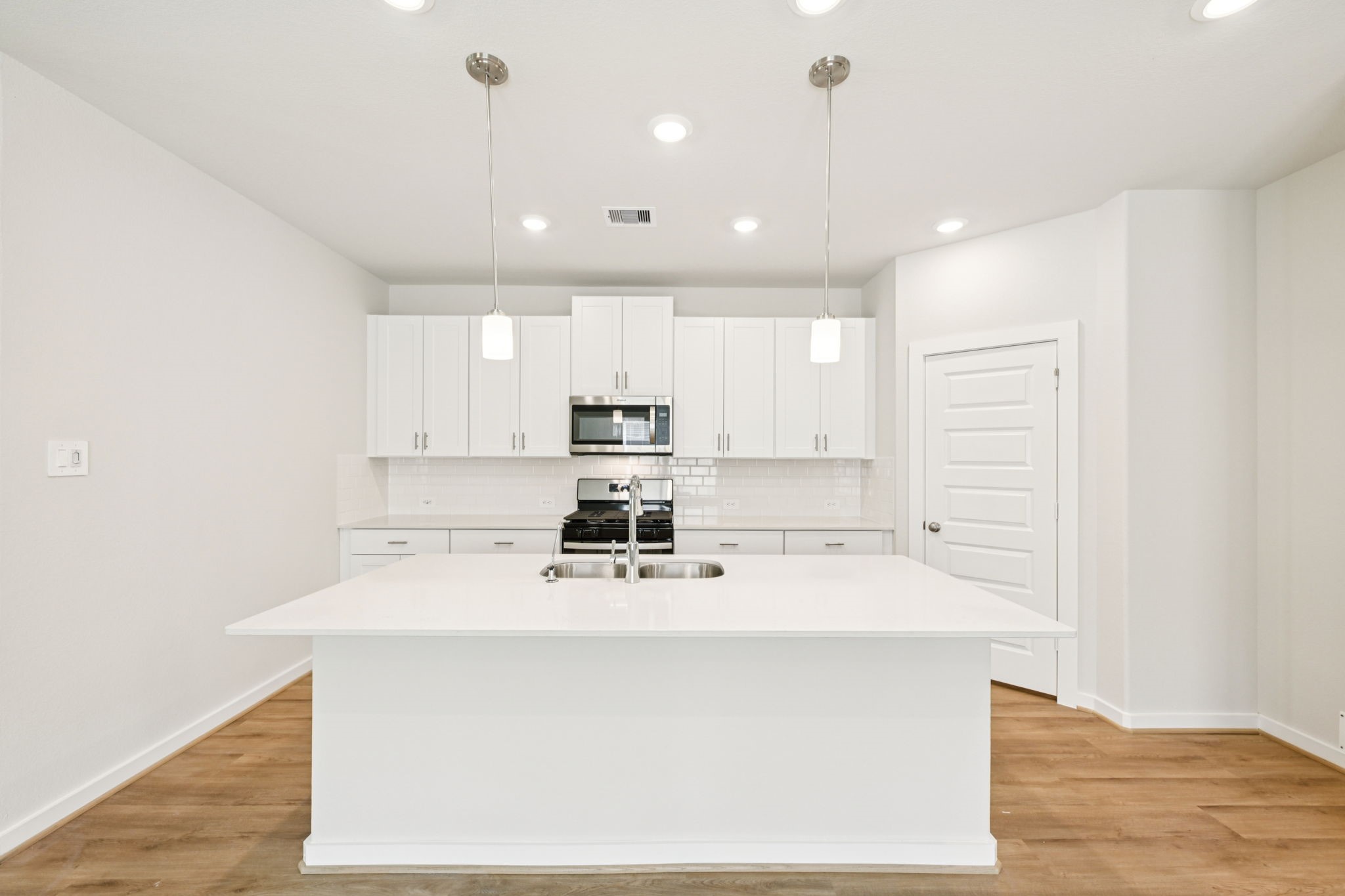 a kitchen with kitchen island a sink stainless steel appliances and cabinets