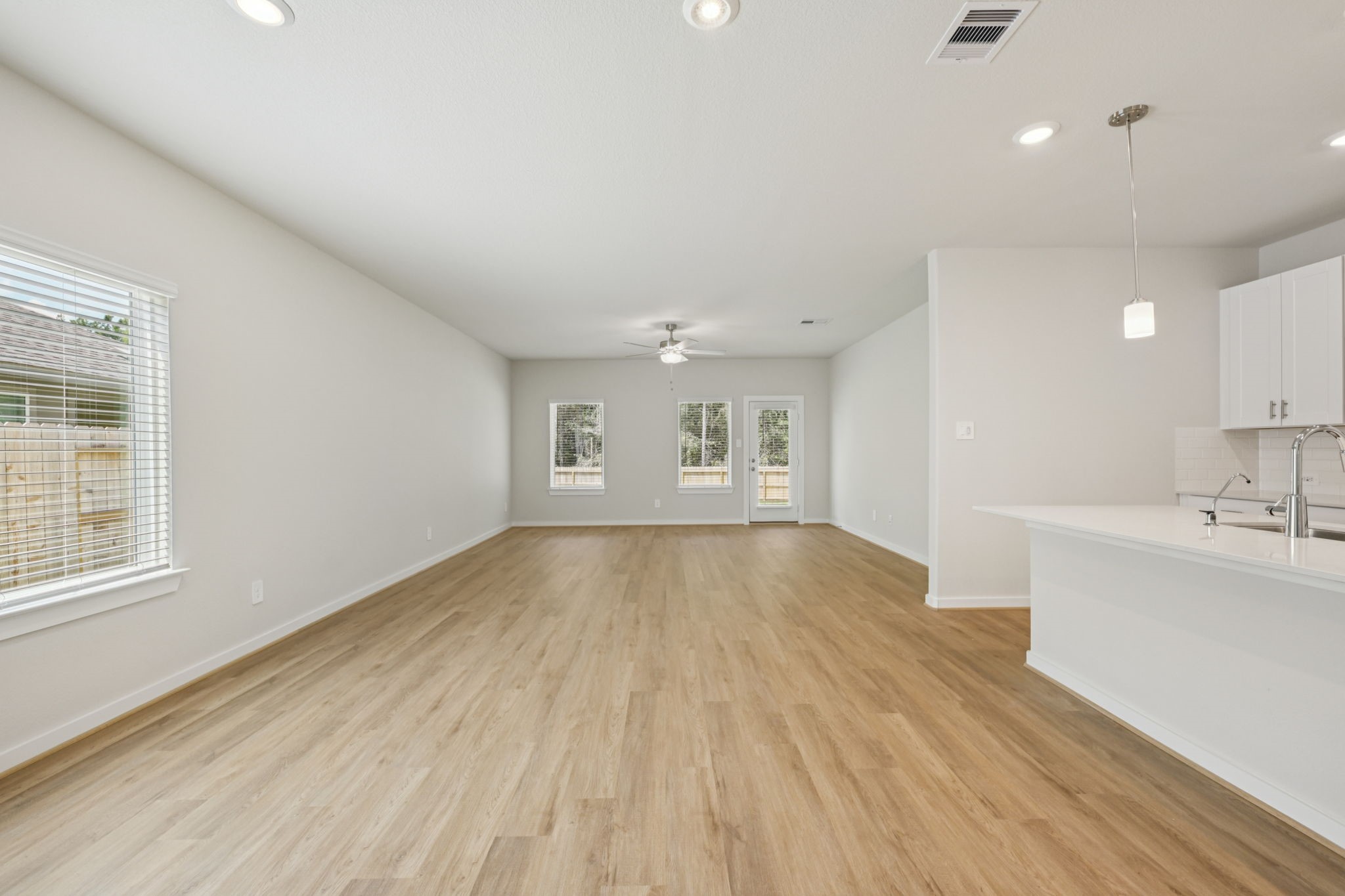 1668 Hopson Ranch Drive Conroe, TX 77301 - Photo 9 of 38 a view of a kitchen with wooden floor and a sink