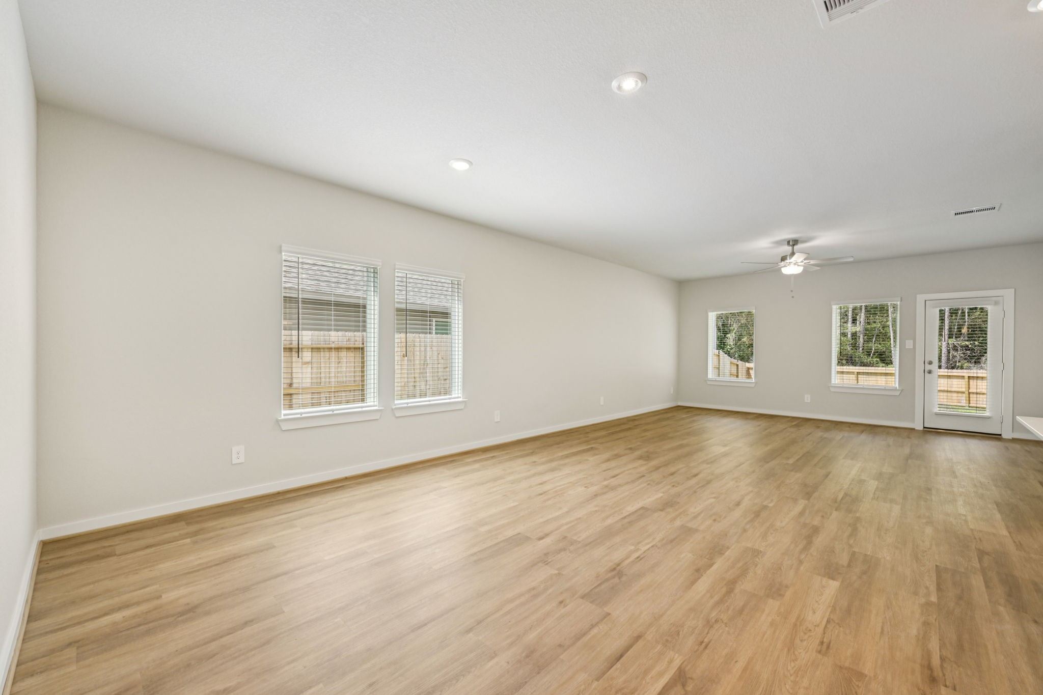 1668 Hopson Ranch Drive Conroe, TX 77301 - Photo 10 of 38 an empty room with wooden floor and windows