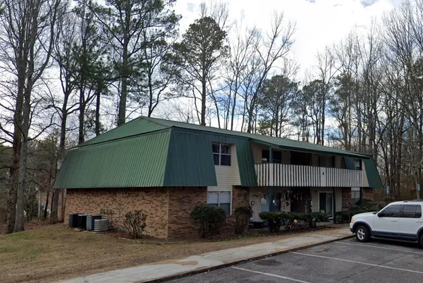 a front view of a house with cars parked