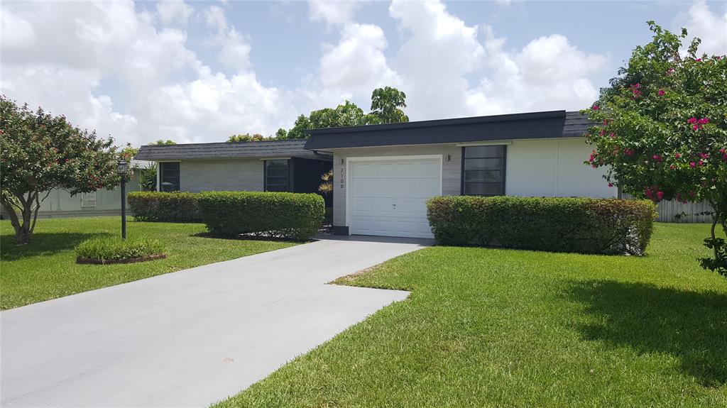 7108 Northwest 66th Street Tamarac, FL 33321 - Photo 1 of 23 a front view of a house with a yard and garage