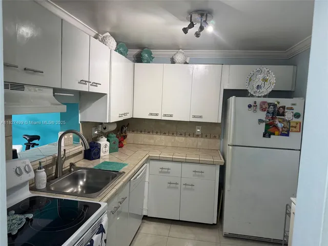 a kitchen with white cabinets and white appliances