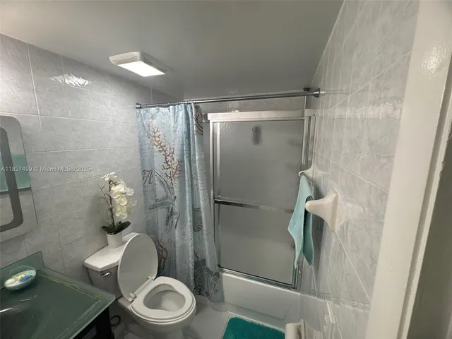 a bathroom with a granite countertop sink a mirror and a toilet