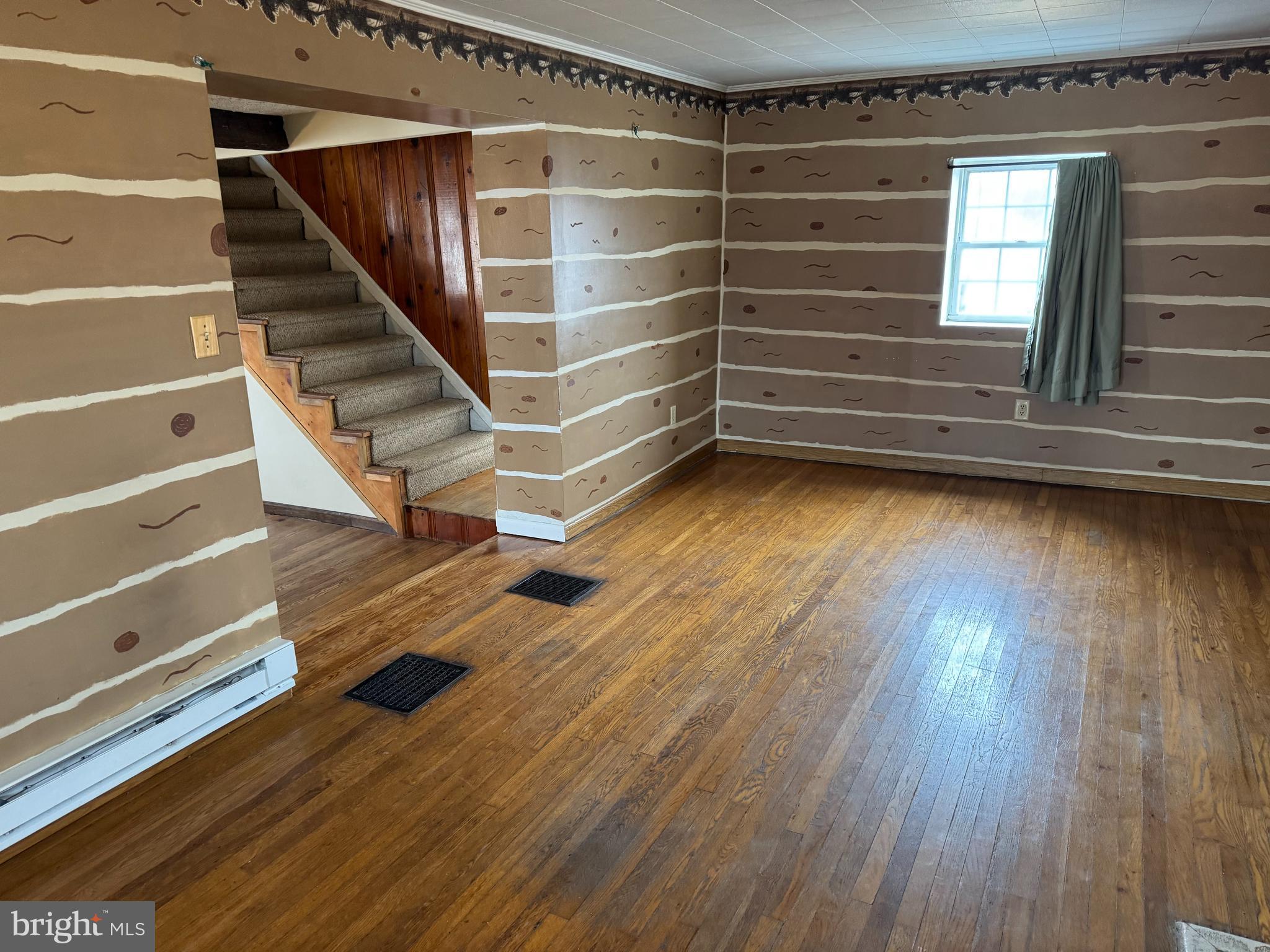 3959 Warm Spring Road Chambersburg, PA 17202 - Photo 4 of 13 a view of an empty room with stairs and a wooden floor