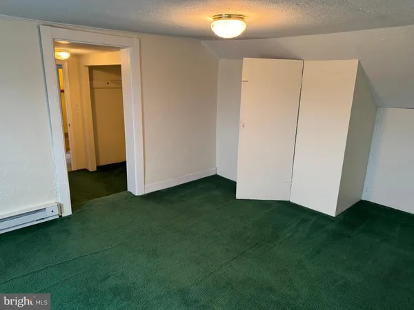a view of an empty room with closet and a fireplace