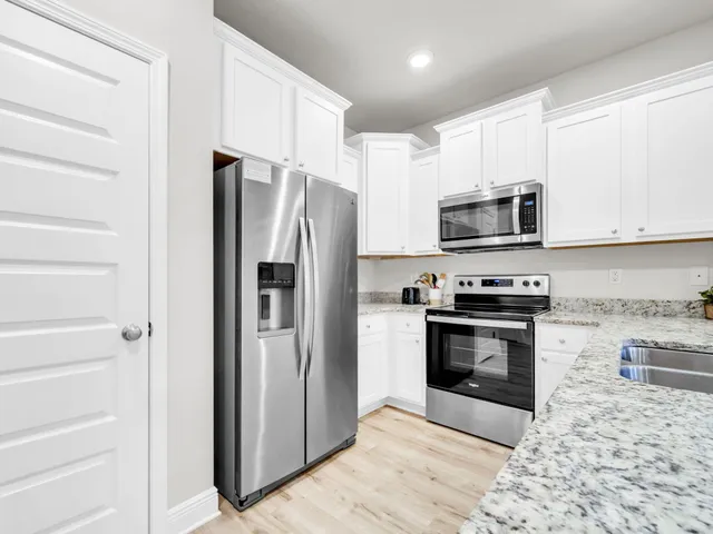 a kitchen with stainless steel appliances granite countertop a refrigerator stove and microwave
