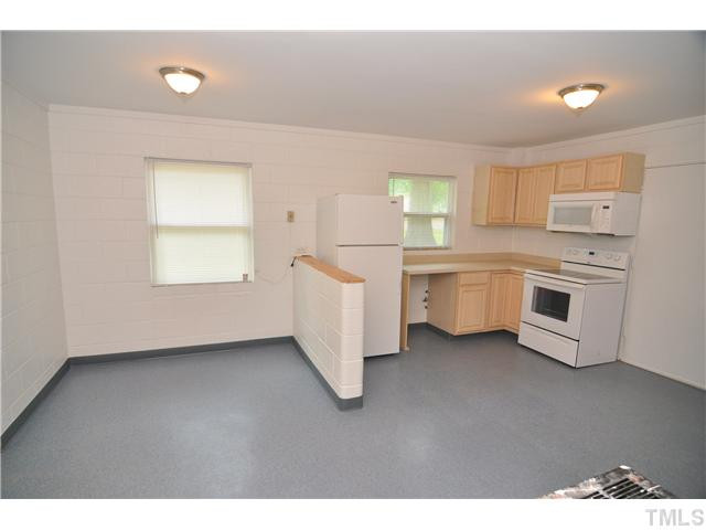 1705 Cheek Road Durham, NC 27704 - Photo 6 of 25 a kitchen with white cabinets and white appliances