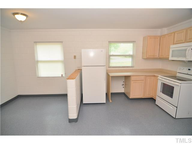 1705 Cheek Road Durham, NC 27704 - Photo 7 of 25 a kitchen with a white cabinets and white appliances