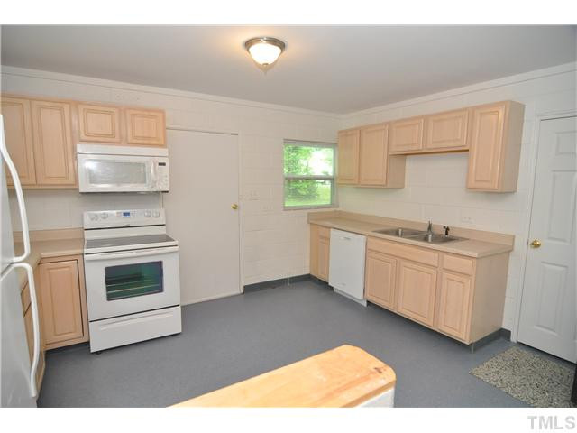 1705 Cheek Road Durham, NC 27704 - Photo 10 of 25 a kitchen with granite countertop white cabinets and white appliances