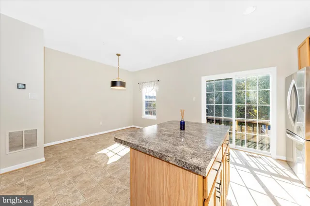 a kitchen with kitchen island granite countertop a stove and a granite counter tops with white walls