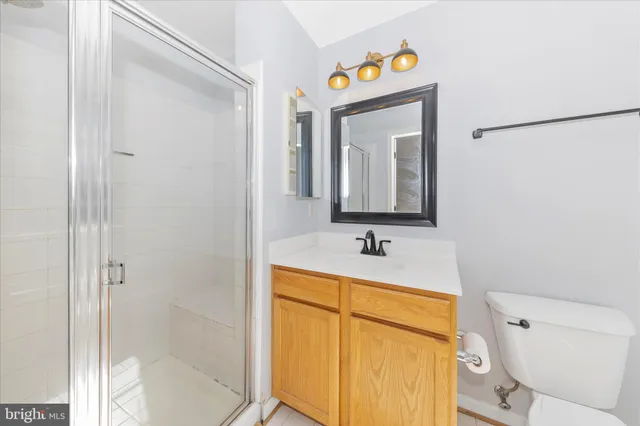 a bathroom with a toilet sink vanity and mirror