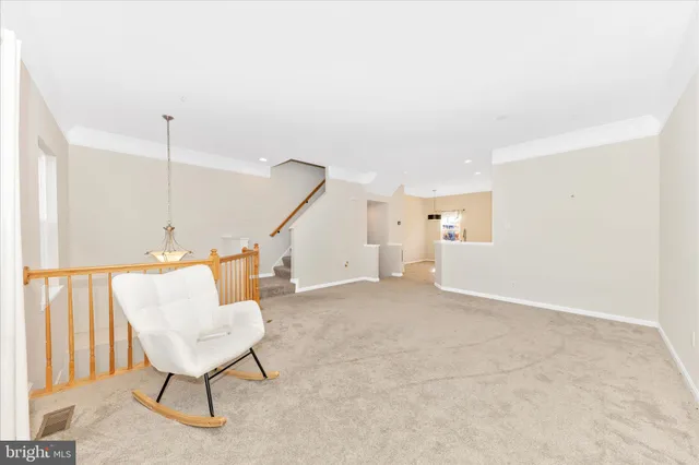 a view of an empty room with stairs and a couch