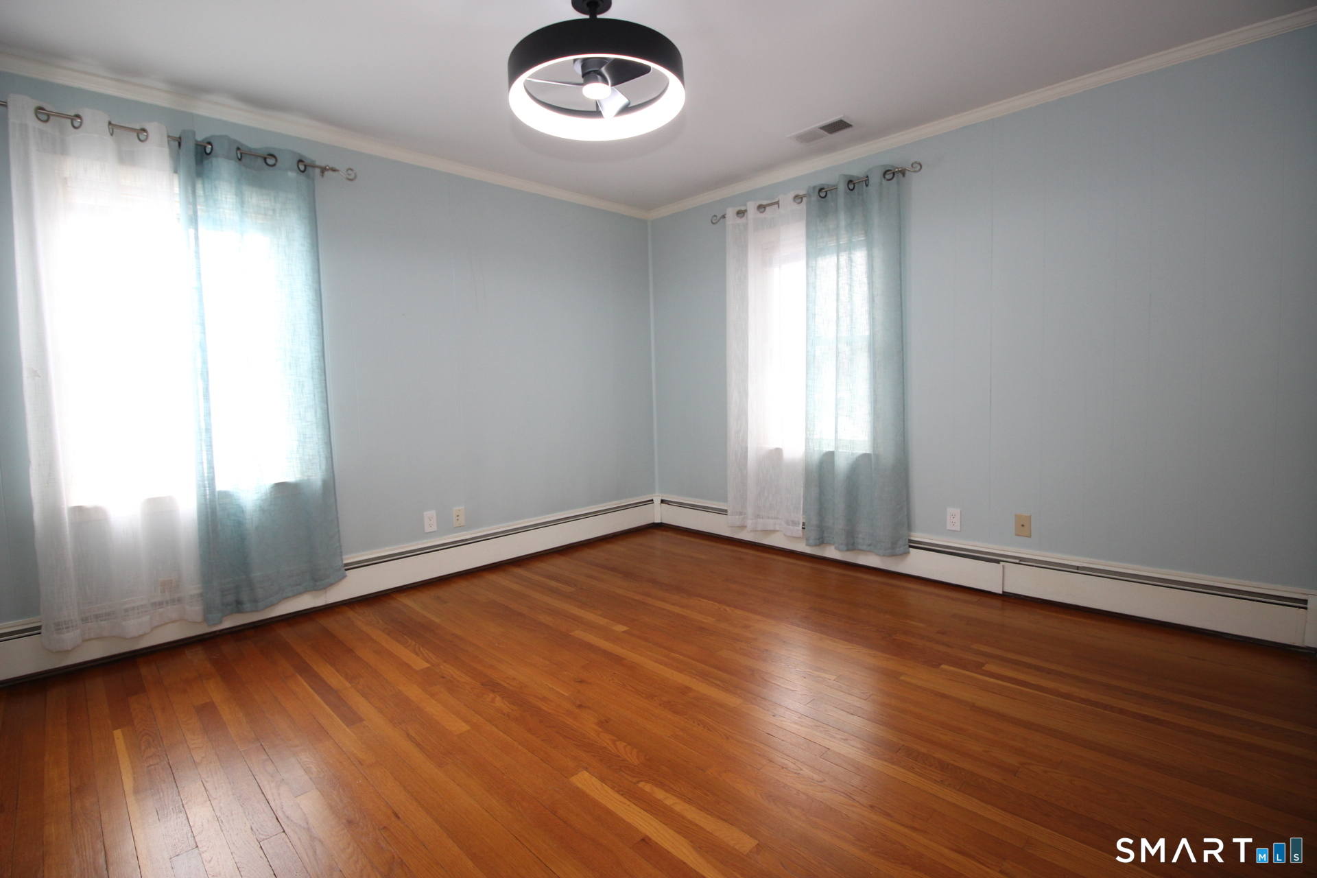 76 Elliott Road Trumbull, CT 06611 - Photo 11 of 26 an empty room with wooden floor and windows