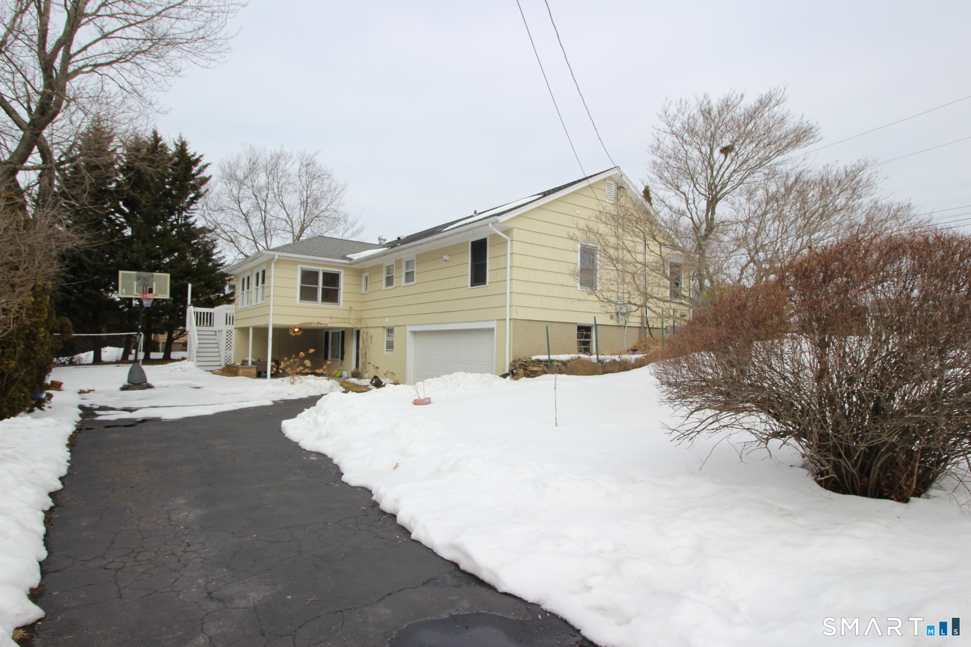 76 Elliott Road Trumbull, CT 06611 - Photo 25 of 26 a front view of a house with a yard covered in snow