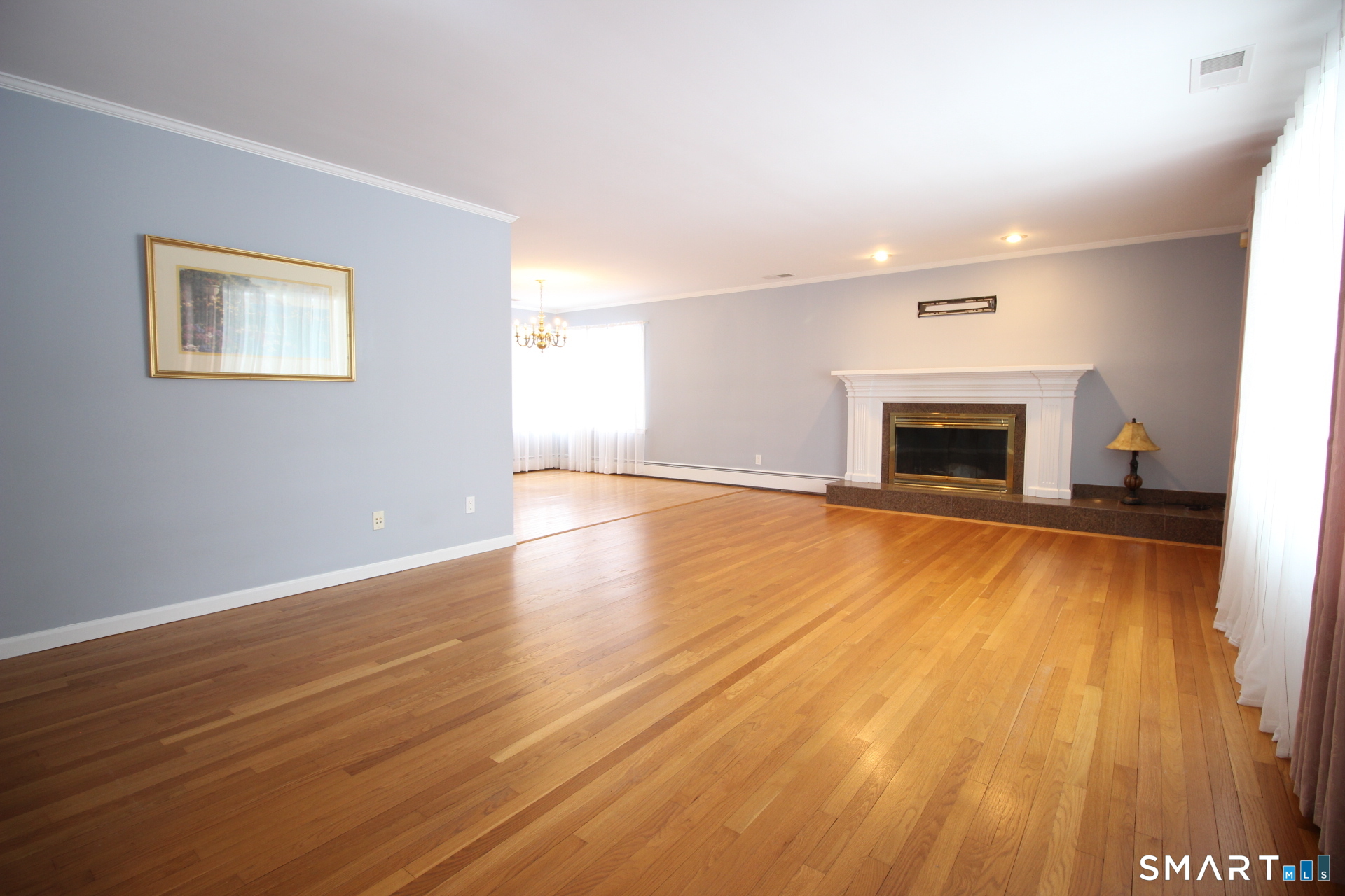 76 Elliott Road Trumbull, CT 06611 - Photo 3 of 26 a view of an empty room with wooden floor fireplace and a window