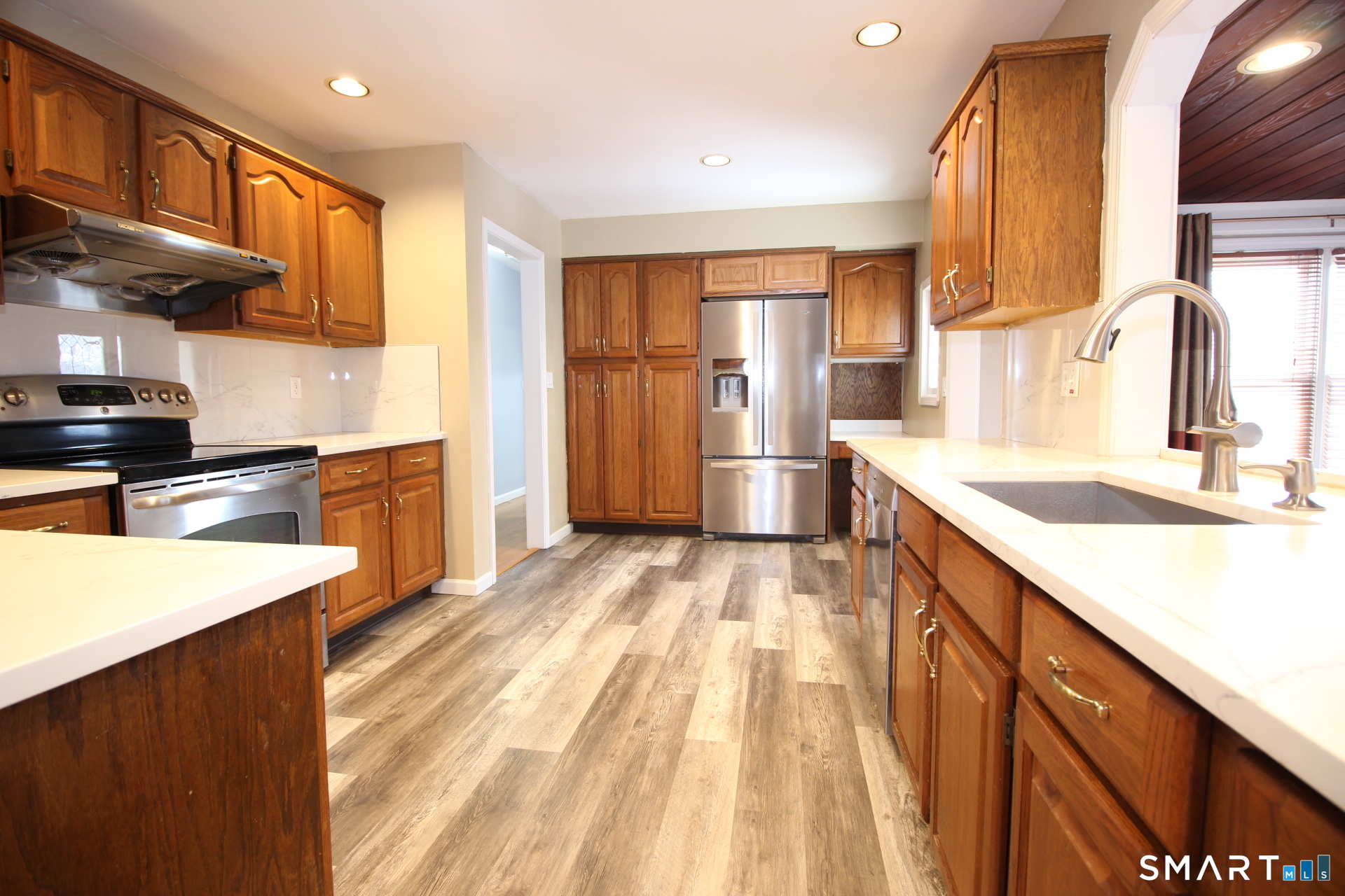 76 Elliott Road Trumbull, CT 06611 - Photo 7 of 26 a kitchen with stainless steel appliances granite countertop a sink a stove and a refrigerator