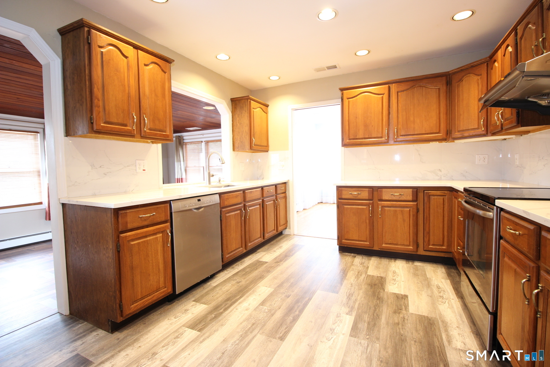 76 Elliott Road Trumbull, CT 06611 - Photo 8 of 26 a kitchen with stainless steel appliances granite countertop wooden cabinets a sink and dishwasher a stove with wooden floor