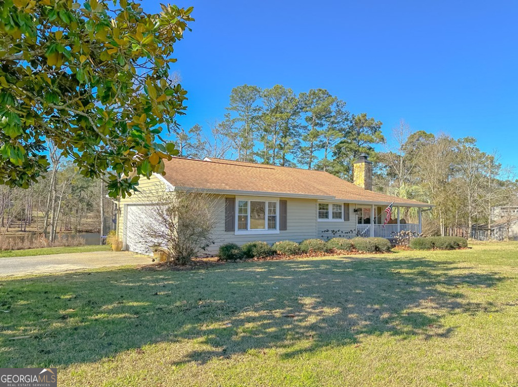 218 Hidden Springs Road Climax, GA 39834 - Photo 4 of 35 a front view of a house with a garden and trees
