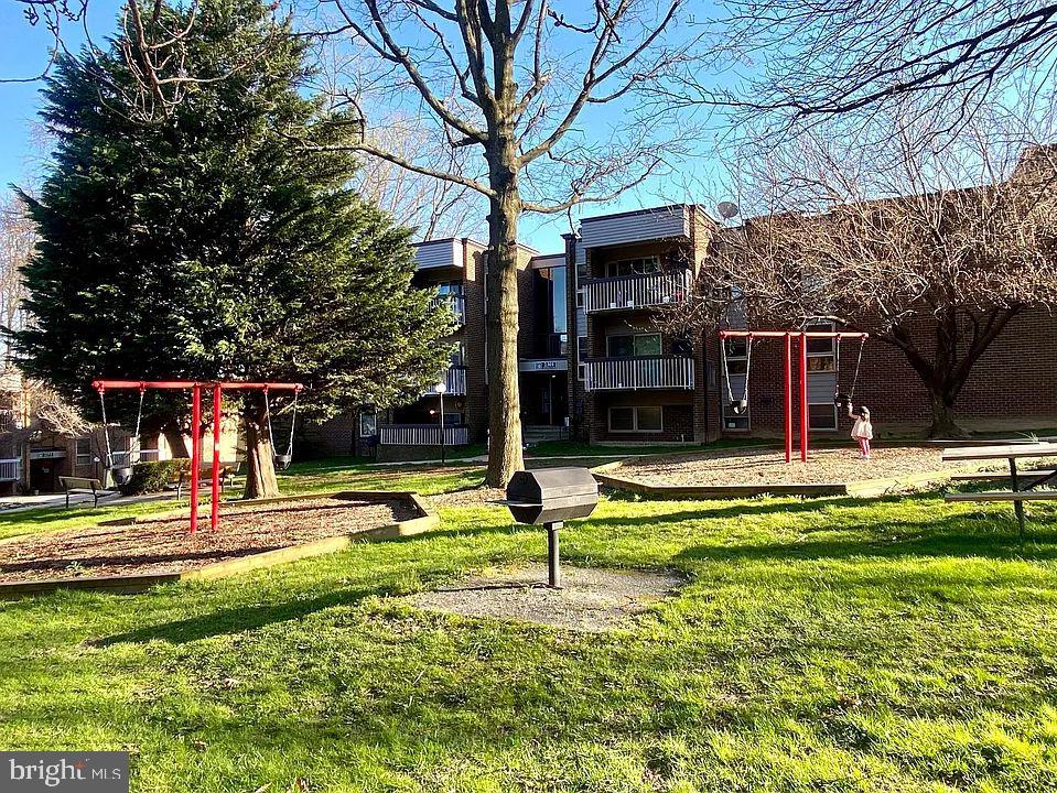 2305 Greenery Lane, Unit 1023 Silver Spring, MD 20906 - Photo 19 of 23 a view of a swimming pool with a table and chairs under an umbrella