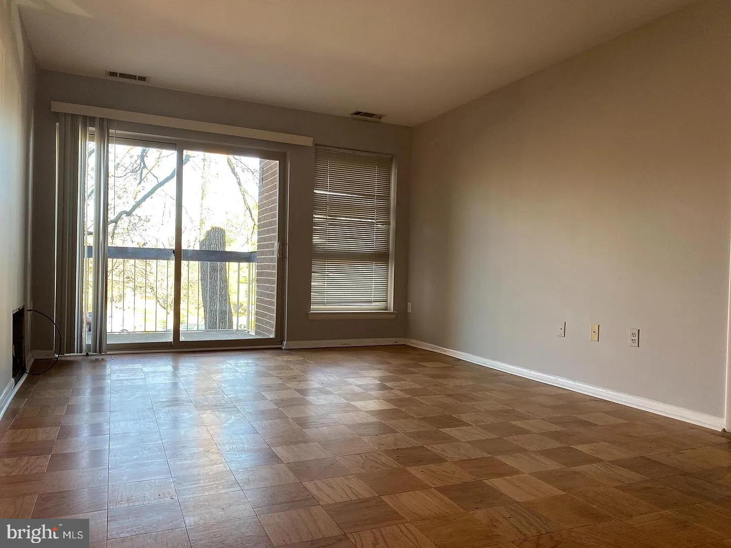 2305 Greenery Lane, Unit 1023 Silver Spring, MD 20906 - Photo 6 of 23 wooden floor in an empty room with a window