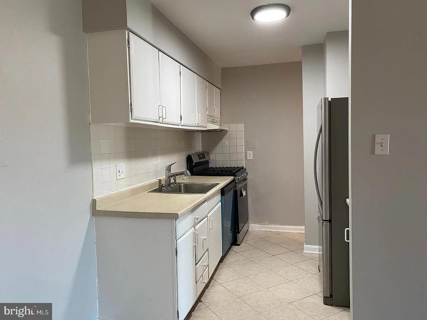 2305 Greenery Lane, Unit 1023 Silver Spring, MD 20906 - Photo 8 of 23 a kitchen with a sink and a refrigerator