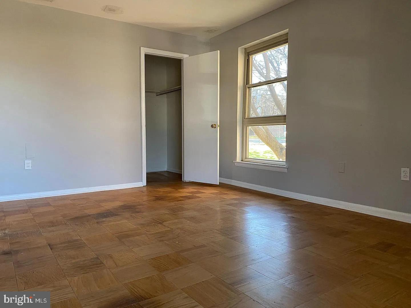 2305 Greenery Lane, Unit 1023 Silver Spring, MD 20906 - Photo 9 of 23 an empty room with wooden floor and windows