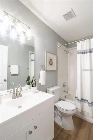 a bathroom with a double vanity sink toilet mirror and bathtub