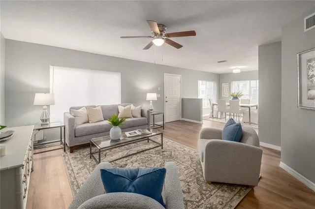 a living room with furniture and a wooden floor