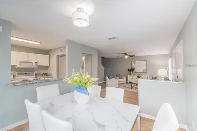 a dining room filled chandelier and kitchen view