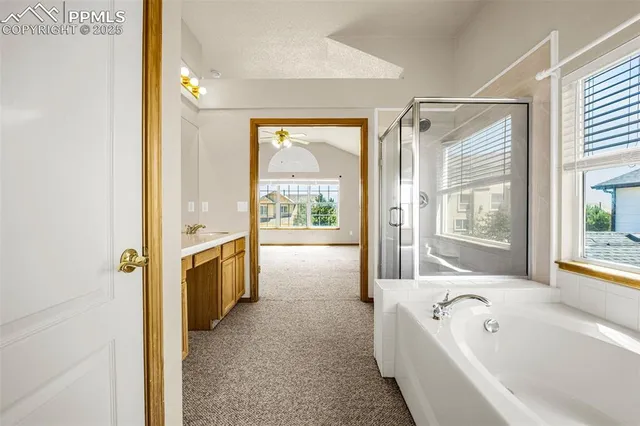 a bathroom with a tub a sink a mirror and a shower