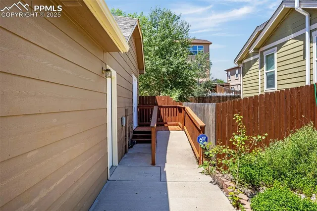 a view of a pathway of a house with wooden fence
