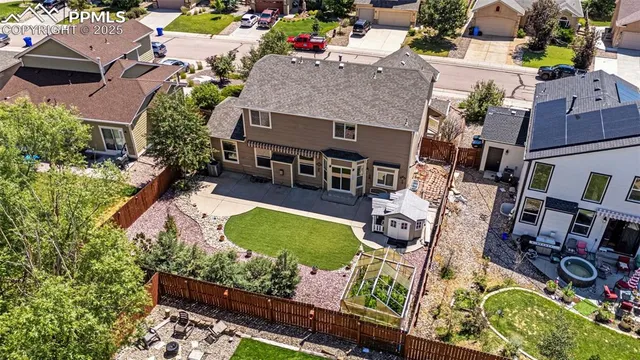 an aerial view of a house with garden space and street view