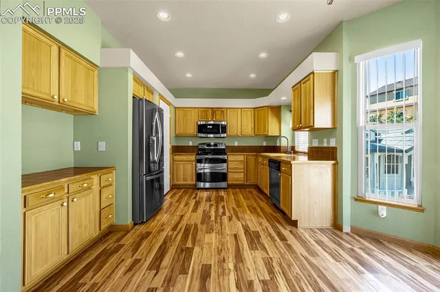 a kitchen with stainless steel appliances a refrigerator and wooden cabinets