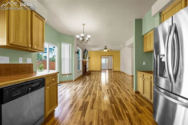 a view of a kitchen with a sink wooden floor and stainless steel appliances