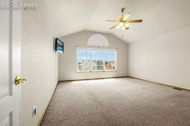 an empty room with fan and windows