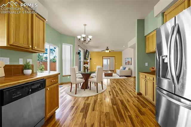 a kitchen with sink a refrigerator and chairs