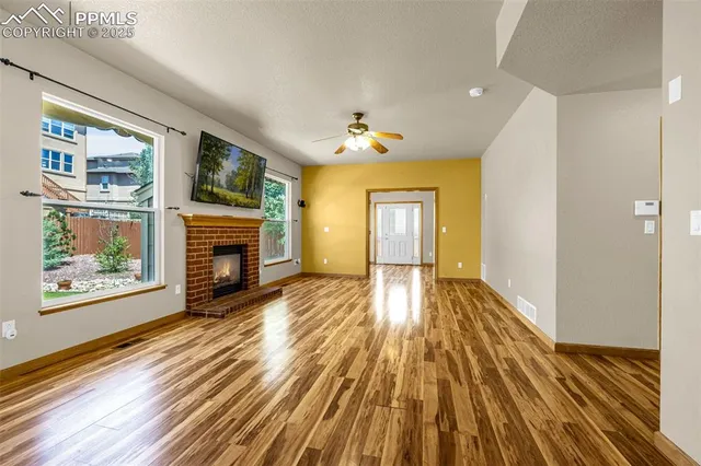 a view of empty room with wooden floor and fireplace