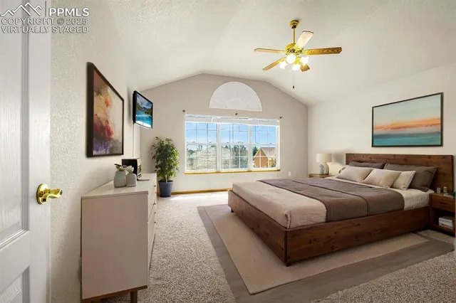 a spacious bedroom with a large bed and a chandelier