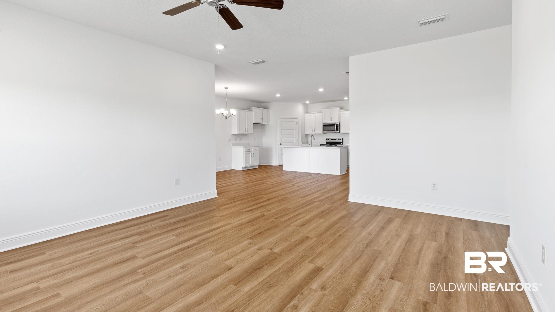 12931 Grand Rpds Road Fairhope, AL 36532 - Photo 20 of 33 Unfurnished living room featuring visible vents, baseboards, light wood-type flooring, recessed lighting, and ceiling fan with notable chandelier