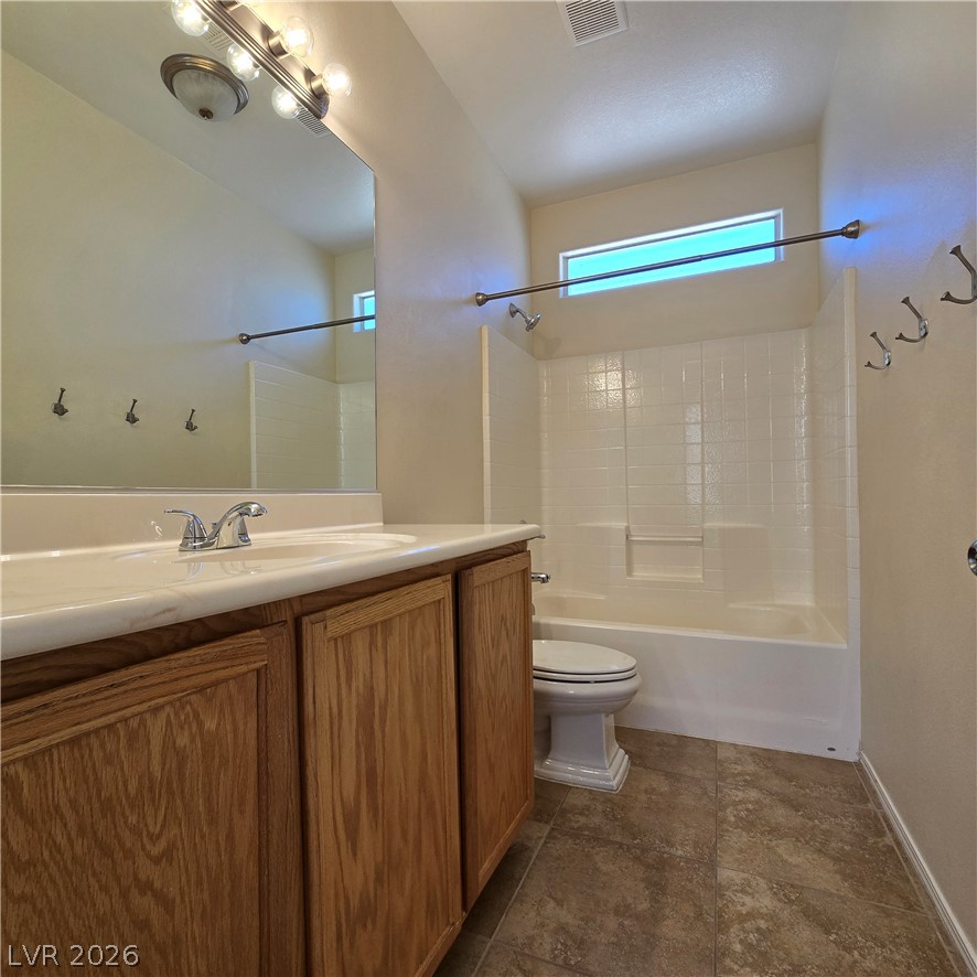 9234 Kingston Road Henderson, NV 89074 - Photo 22 of 38 A classic vanity with ample storage complements the neatly tiled shower-tub combo in this well-appointed bathroom.