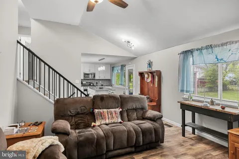 a living room with furniture ceiling fan and a window