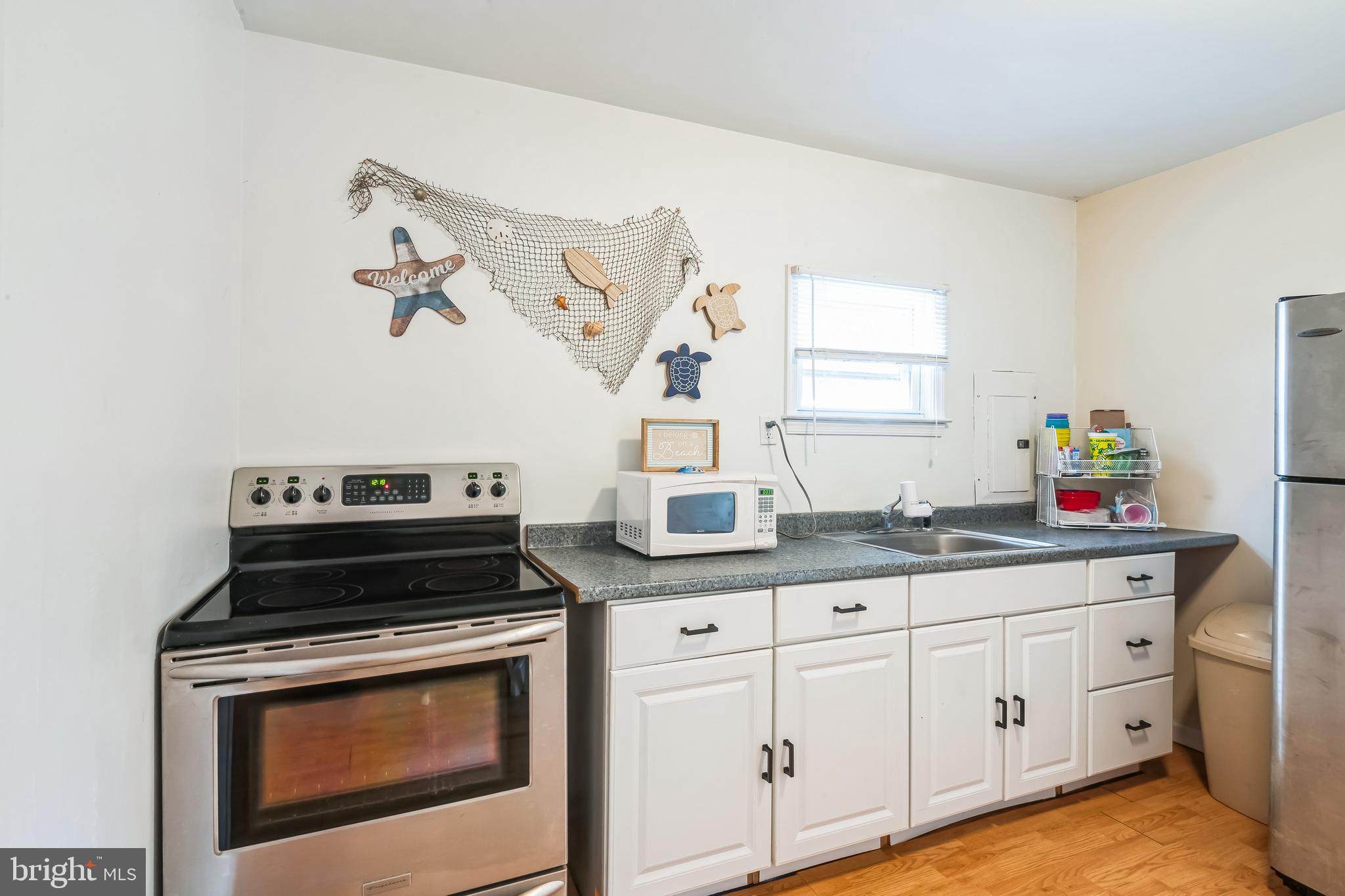 13 Paula Lane Villas, NJ 08251 - Photo 11 of 30 a kitchen with granite countertop a stove a sink and dishwasher with wooden floor