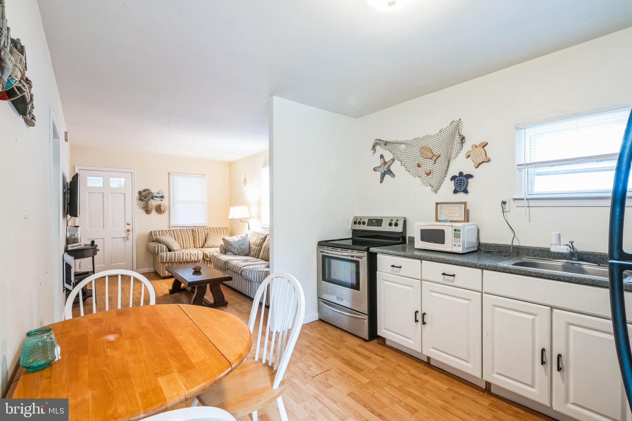 13 Paula Lane Villas, NJ 08251 - Photo 4 of 30 a kitchen with stainless steel appliances granite countertop a stove a sink a dining table and chairs