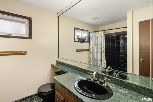 a bathroom with a sink a toilet and a mirror