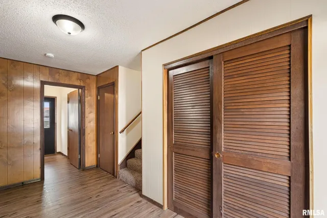 a view of hallway with stairs and wooden floor