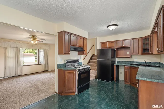 a kitchen with stainless steel appliances granite countertop a stove refrigerator sink and dishwasher