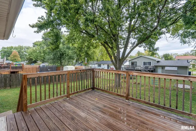 a view of a balcony with wooden floor and fence