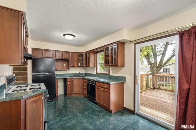 a kitchen with stainless steel appliances granite countertop a refrigerator a stove top oven a sink and dishwasher