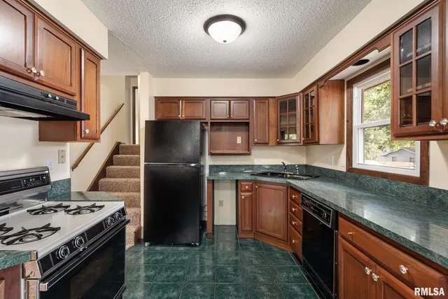a kitchen with stainless steel appliances granite countertop a stove sink and refrigerator